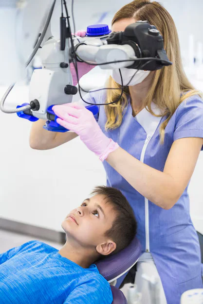 Dentist Checking teeth boy through Microscope Clinic